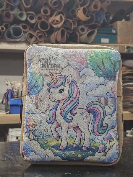 Unicorn-themed pouch on a dark surface with colorful background